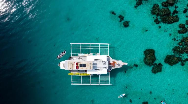Catamarano all’ancora in acqua trasparente, visto dall’alto
