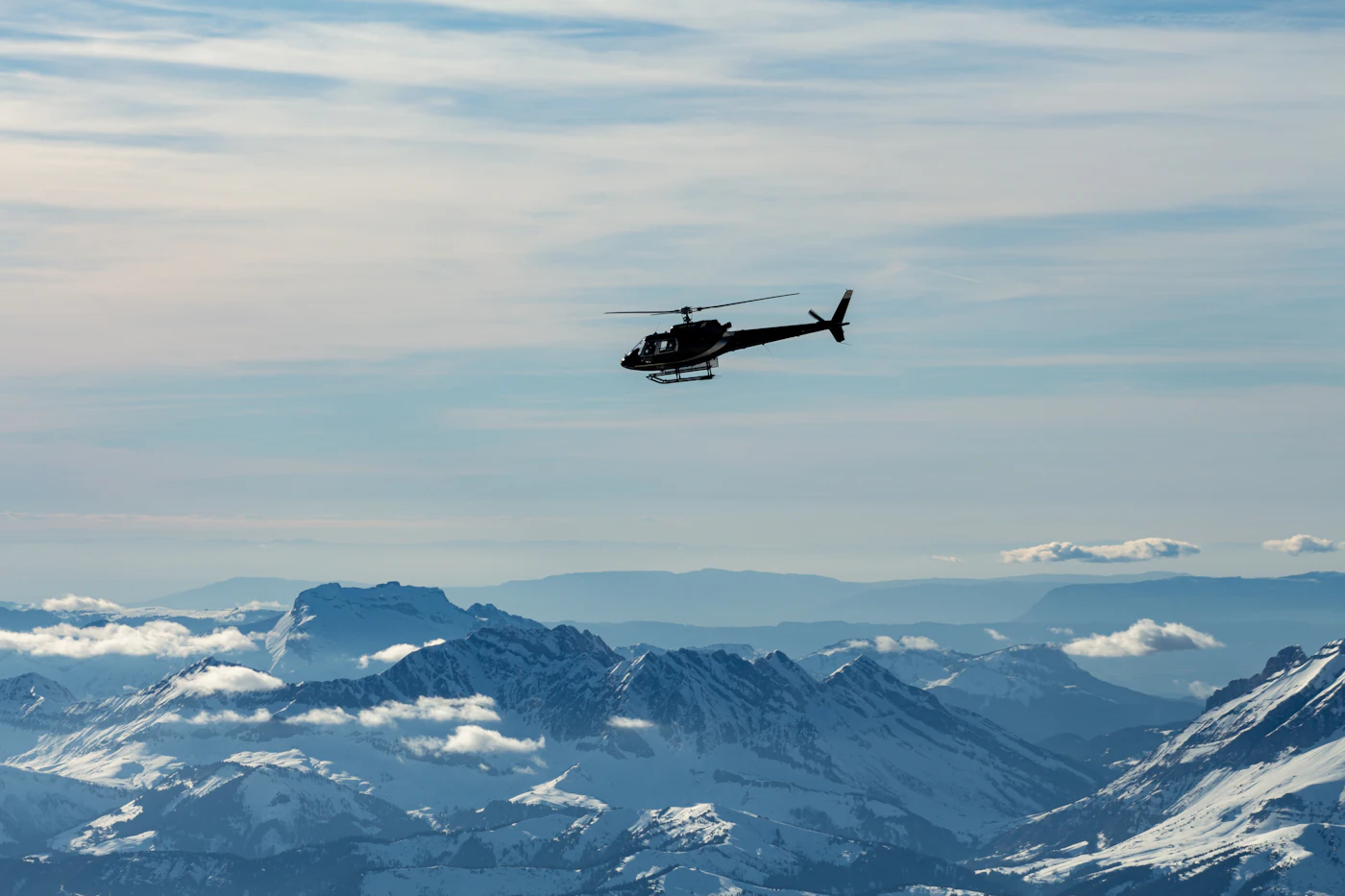 Helicopter above snow-capped mountains