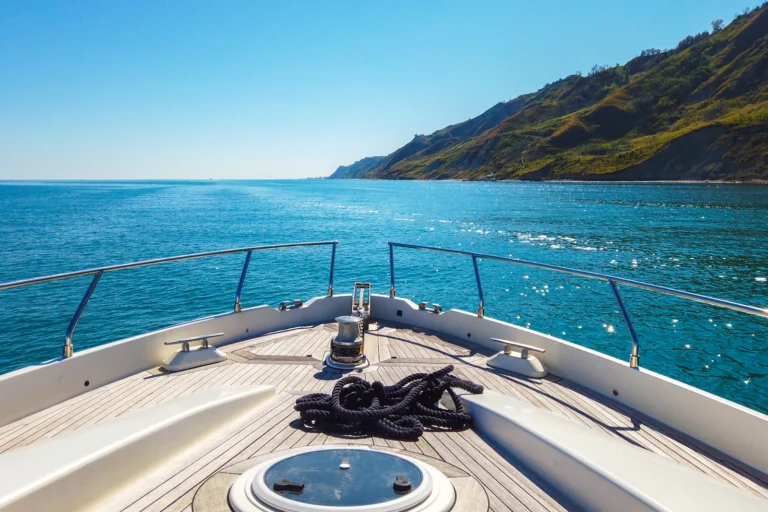 Prua di uno yacht davanti alla costa