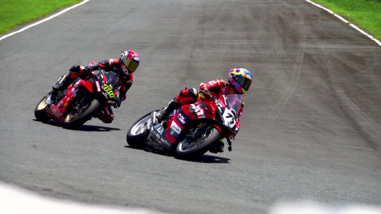 Due piloti in piega in curva durante una gara di moto